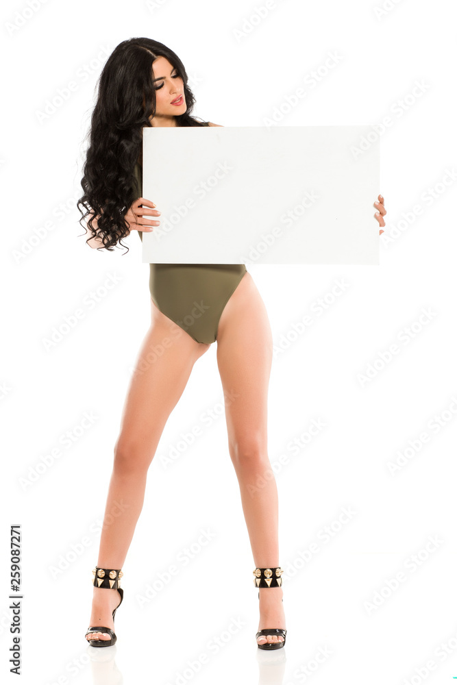 Attractive brunette with blank board in one piece swimsuit on white background Attractive brunette with blank board in one piece swimsuit on white background