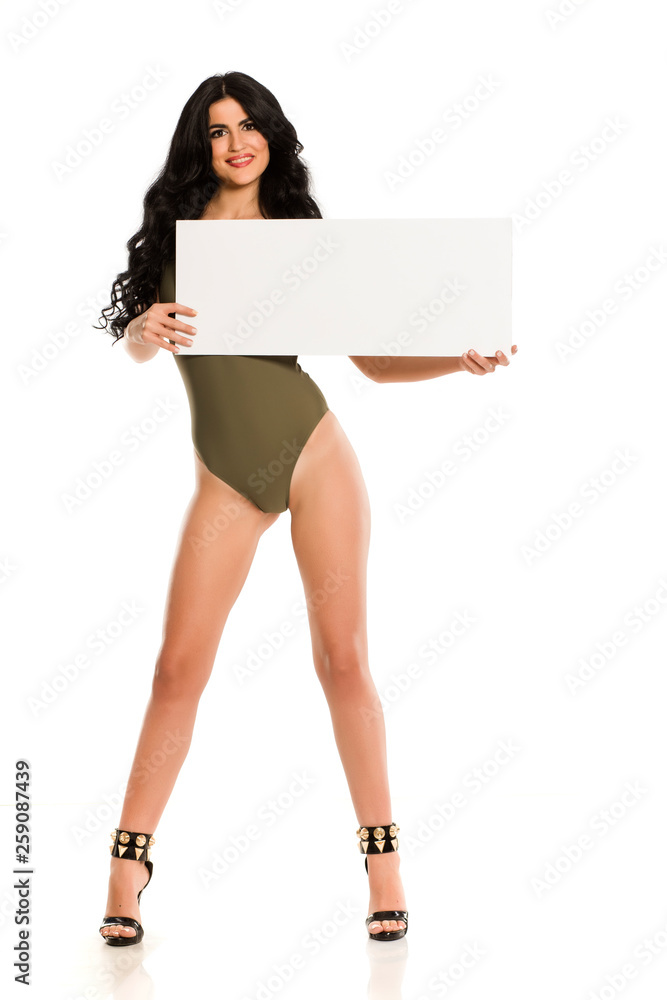 Attractive brunette with blank board in one piece swimsuit on white background Attractive brunette with blank board in one piece swimsuit on white background