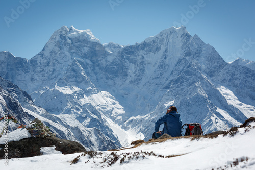 Tableau sur toile A man sits in the mountains on a hill and looks at the horizon