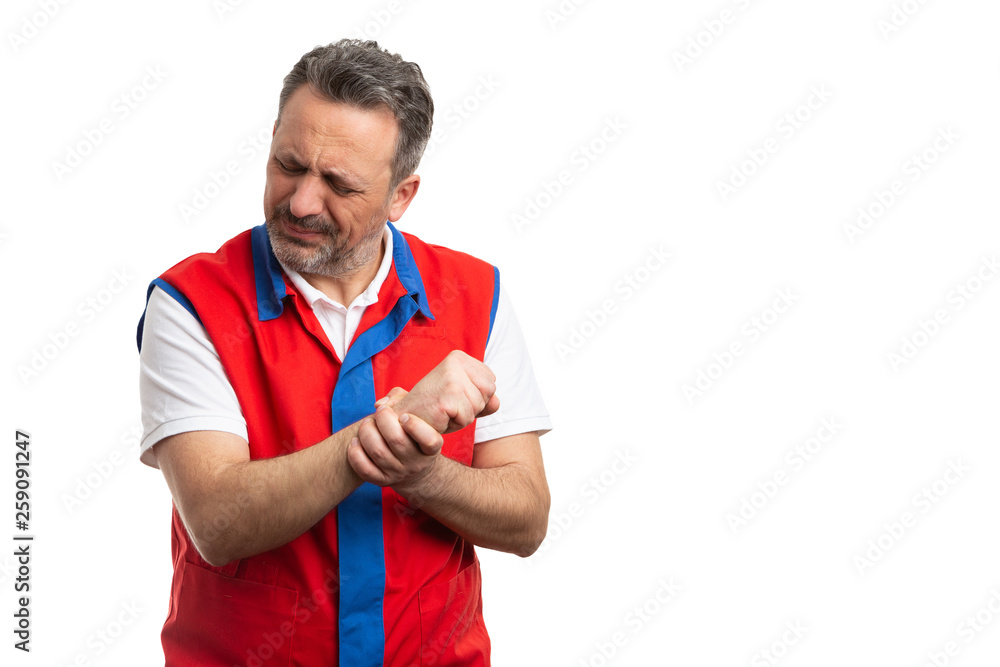 Supermarket employee touching sprained wrist. Supermarket employee touching sprained wrist.