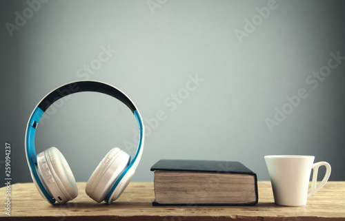 Headphones and book on wooden table. Audio book concept