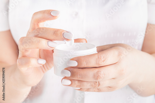 Closeup shot of woman hands applying moisturizing hand cream