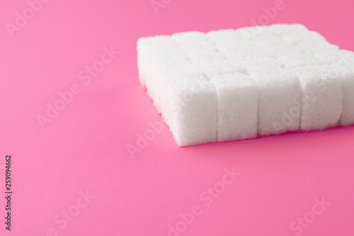 Cubes of sugar on a pink background. Empty space for copying text