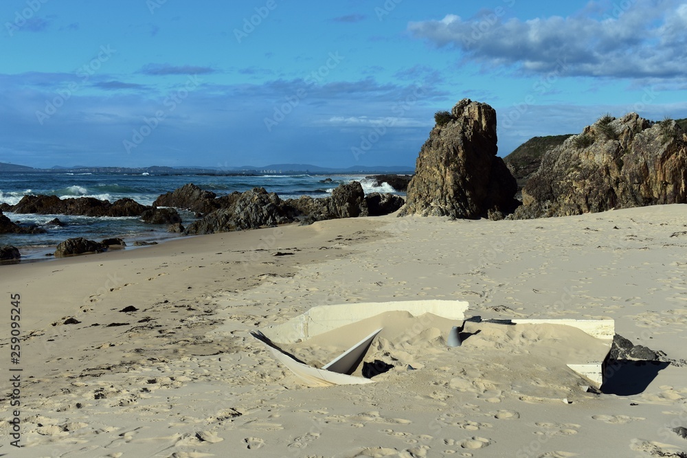 Shipwrecked fibreglass boat sand filled on a beach