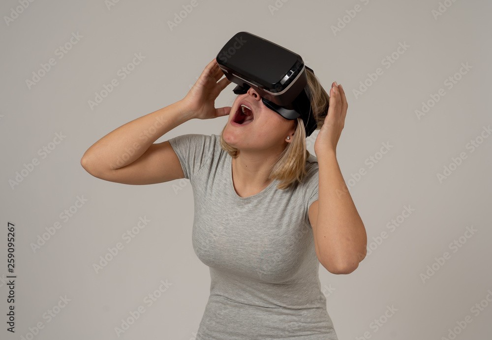 Portrait of cheerful and shocked young woman wearing Virtual Reality headset exploring 3D world Portrait of cheerful and shocked young woman wearing Virtual Reality headset exploring 3D world