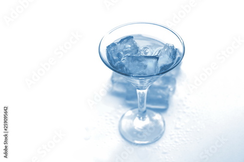 drink in a martini glass with ice cubes.