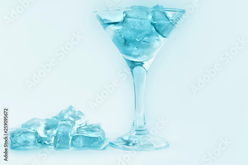 drink in a martini glass with ice cubes.