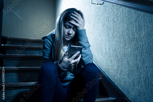 Beautiful lonely young girl depressed and worried suffering from bullying and harassment at school photo