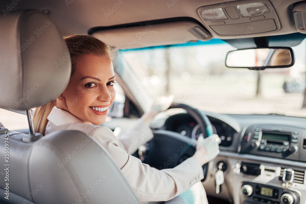 Beautiful businesswoman driving a car, smiling at camera. Beautiful businesswoman driving a car, smiling at camera.