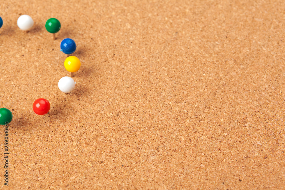 Group of thumbtacks pinned on corkboard Group of thumbtacks pinned on corkboard