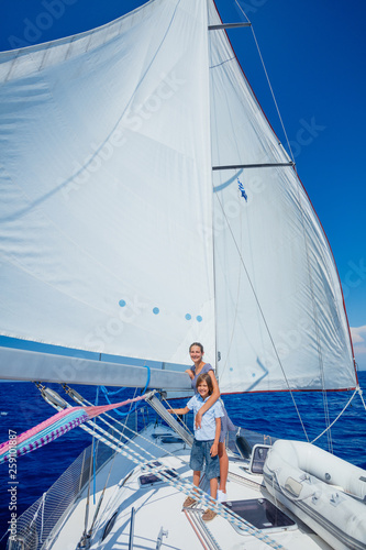 Boy with his sister on board of sailing yacht on summer cruise.
