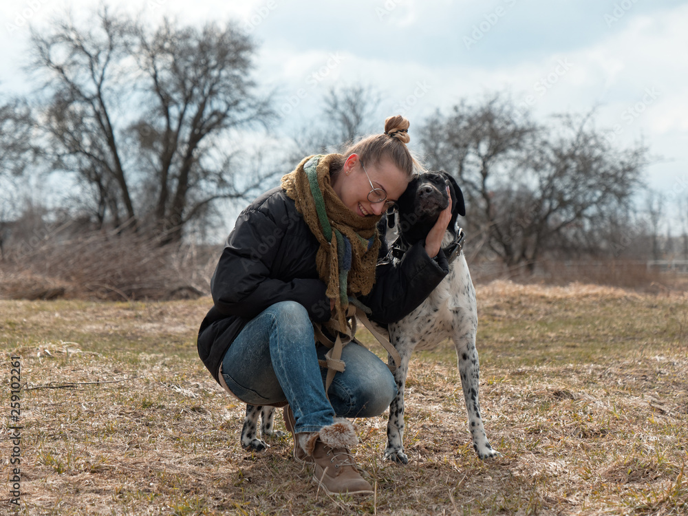 girl walking a big blind dog in the spring