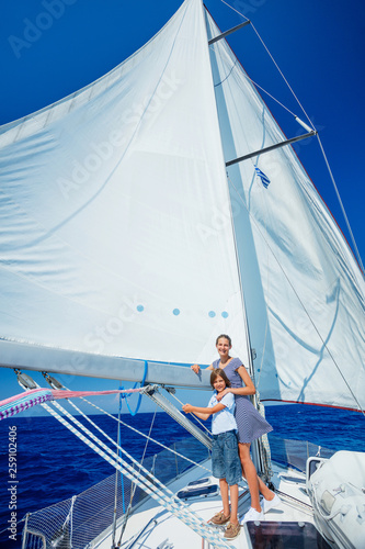 Boy with his sister on board of sailing yacht on summer cruise.