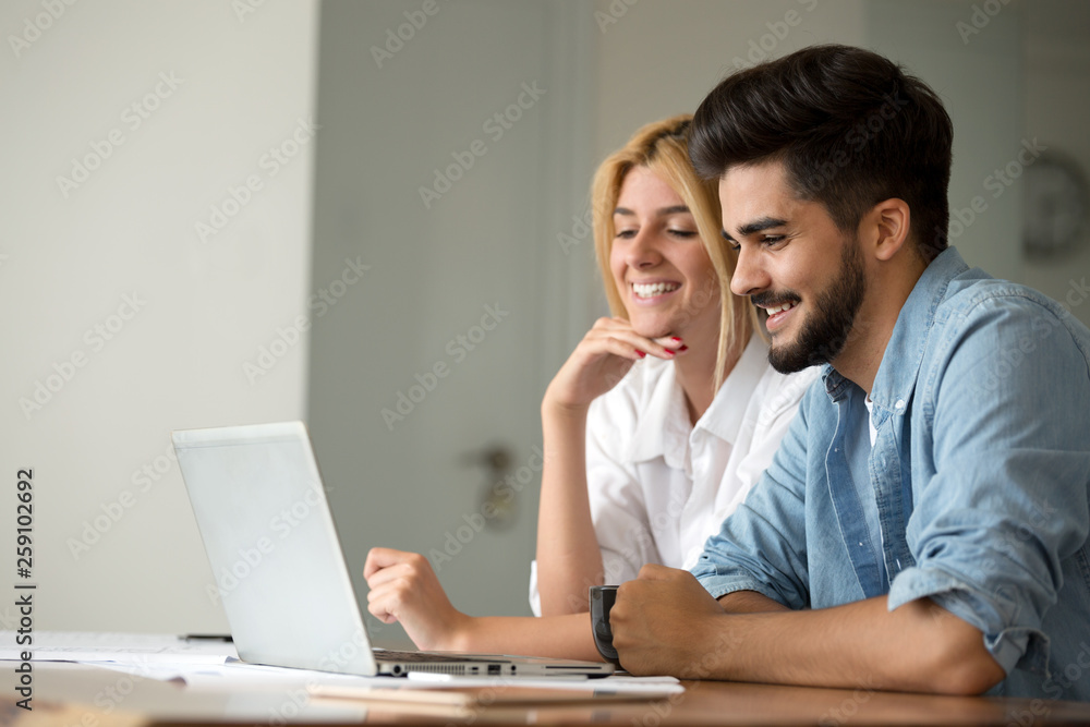 Portrait of a cheerful young couple calculating their bills Portrait of a cheerful young couple calculating their bills