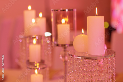 candles on a glass candlestick. Burning candle in a round glass candlestick with decorative seashells