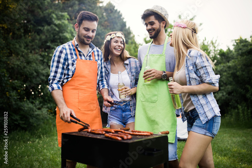 Group of friends having fun in nature doing bbq