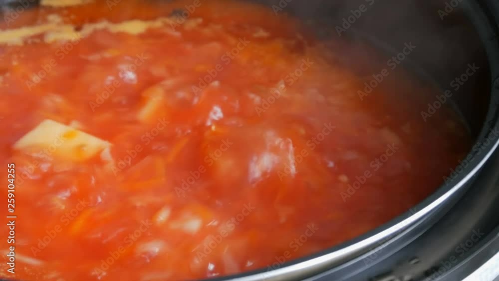 Red vegetable soup or tomato soup is cooked in a pan and boil close up view. Vegetarian cuisine Red vegetable soup or tomato soup is cooked in a pan and boil close up view. Vegetarian cuisine