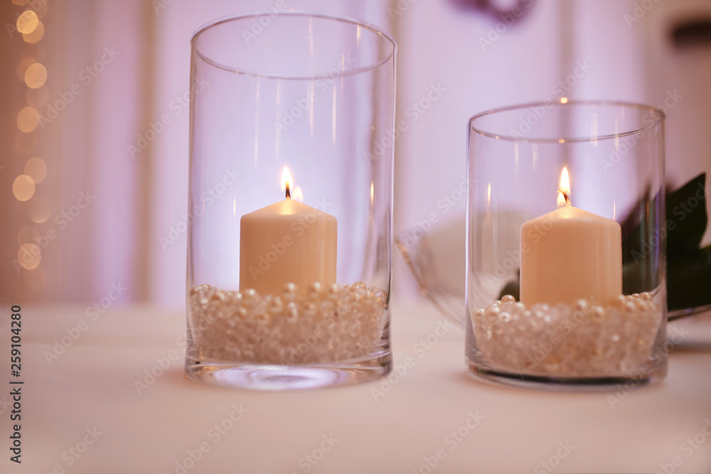 candles on a glass candlestick. Burning candle in a round glass candlestick with decorative seashells candles on a glass candlestick. Burning candle in a round glass candlestick with decorative seashells