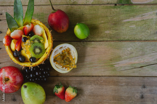 Varied fruits on rustic wooden background. Flat lay.