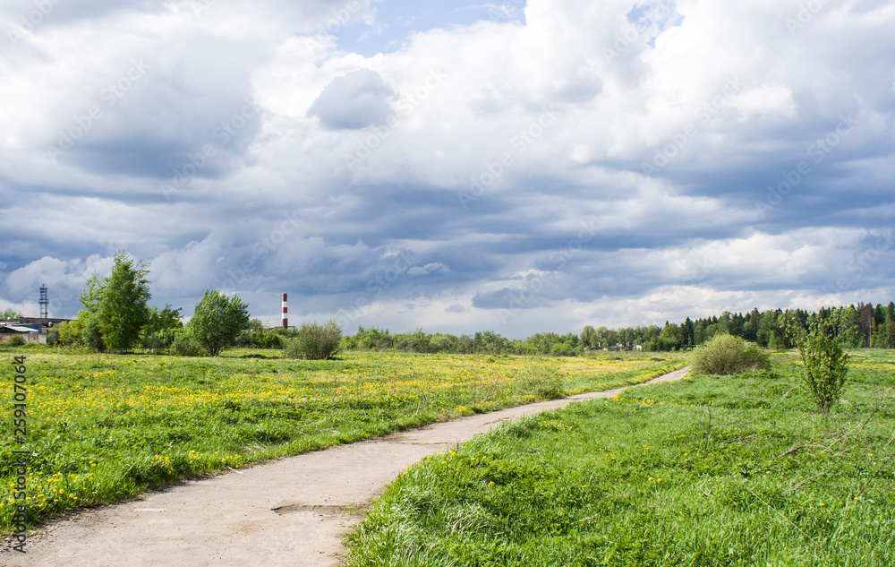 Clouds over the forest. Green meadow outside the city. Beautiful sky. Natural landscape forest. View of the city. Clouds float across the sky. White clouds in the blue sky.