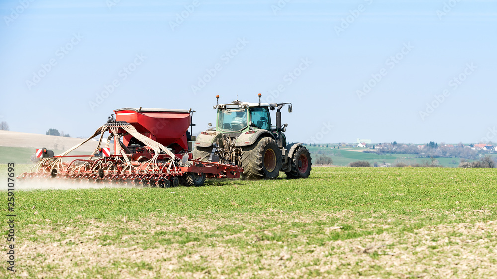 Fototapeta premium tracteur agricole en action sur le champ au printemps
