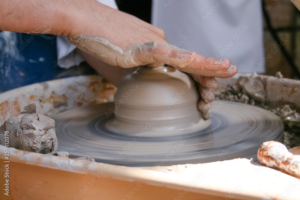 Hands of potter making clay pot