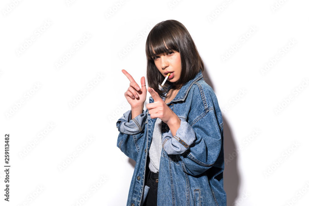 Portrait of a young woman in fur coat and eyeglasses smoking cigarette and looking at camera on white background Portrait of a young woman in fur coat and eyeglasses smoking cigarette and looking at camera on white background