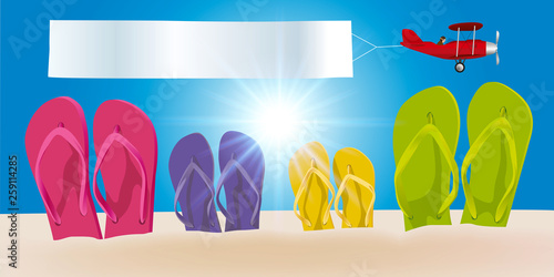 Concept des vacances à la plage par une journée ensoleillée, avec quatre paires de tongs plantées dans le sable et un avion qui passe dans le ciel en tirant une banderole blanche.