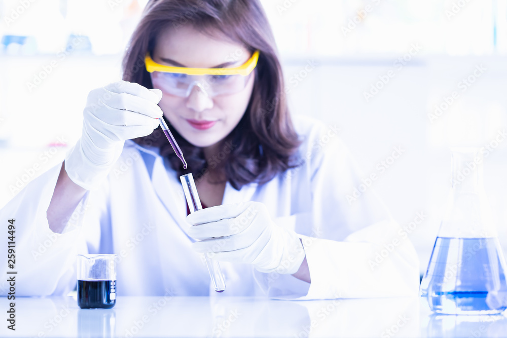 Scientist dropping purple liquid to test tube.. Scientist dropping purple liquid to test tube..