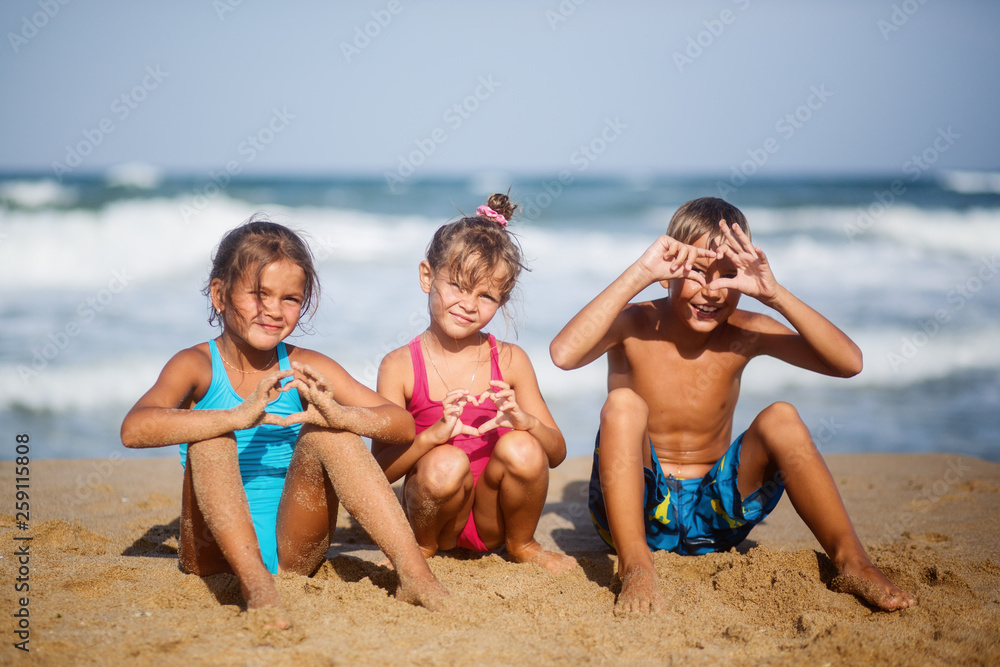 Three children rest on the sea summer of happiness Three children rest on the sea summer of happiness