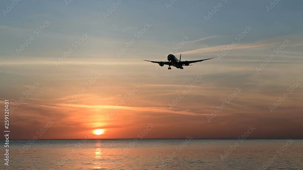 Silhouette of slow motion airplane flying in sunset Silhouette of slow motion airplane flying in sunset