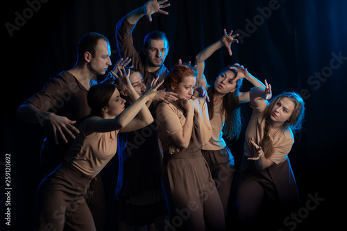 The actors on the stage play an emotion performance on a black background in stage light