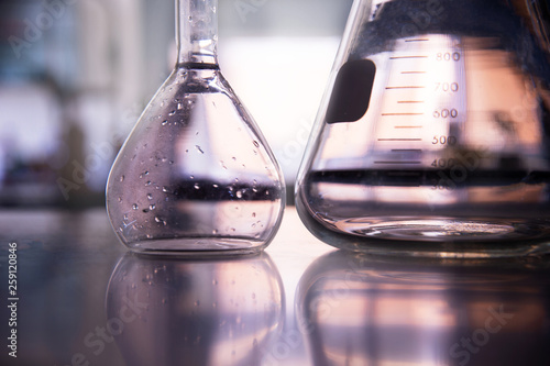 part of volumetric and conical glass flask on education science laboratory background photo