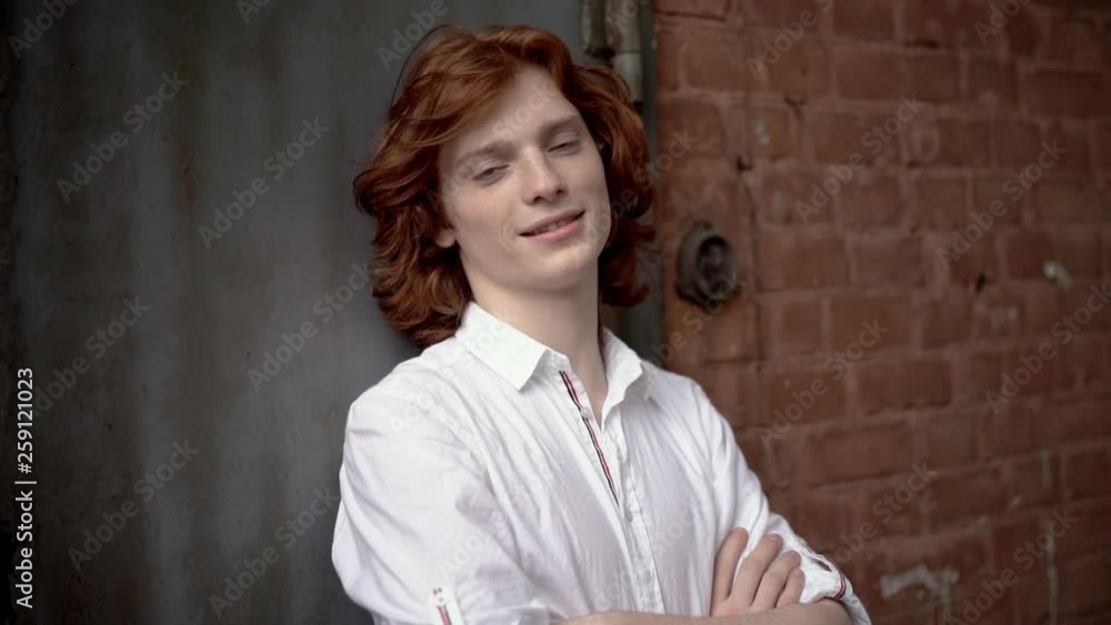 Red-Haired Young Guy in a White Shirt Posing on the Street. Red-Haired Young Guy in a White Shirt Posing on the Street.