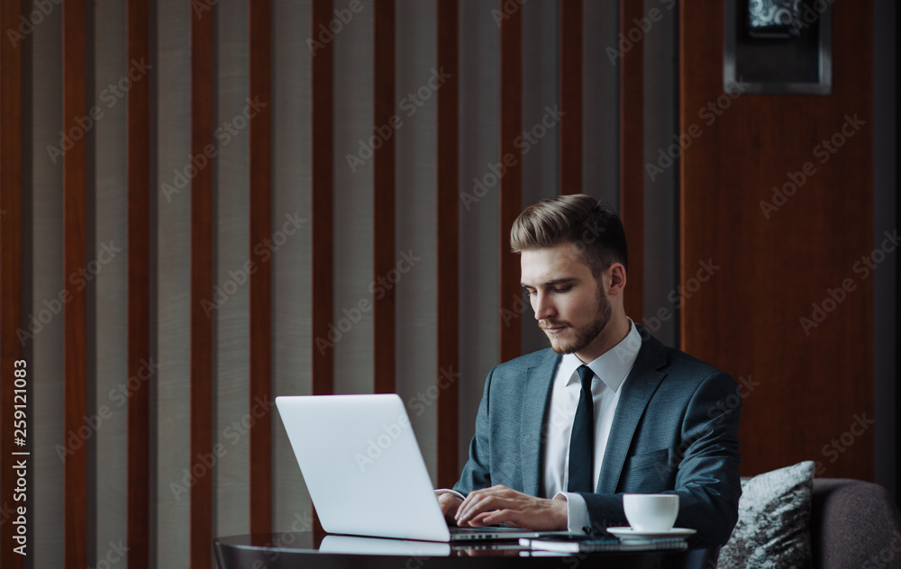 Young businessman working on a plan of Internet project on the laptop. Man discusses business matters by phone. Working computer for internet research. Digital marketing. Development Young businessman working on a plan of Internet project on the laptop. Man discusses business matters by phone. Working computer for internet research. Digital marketing. Development