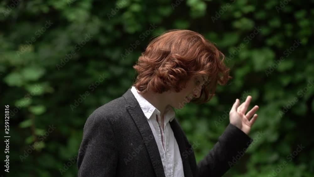 The Red-Haired Guy with Long Hair Dressed in a Suit is in the Garden. The Red-Haired Guy with Long Hair Dressed in a Suit is in the Garden.