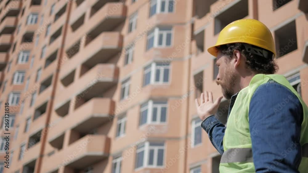 bearded foreman in a yellow helmet at a construction site bearded foreman in a yellow helmet at a construction site