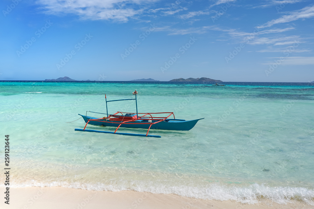 A small blue boat on a tropical beach A small blue boat on a tropical beach