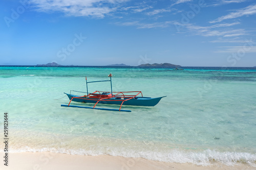 A small blue boat on a tropical beach © takoburito