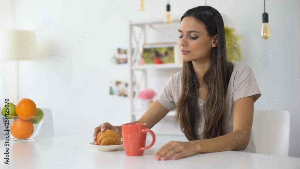 Woman having lunch, drinking coffee with croissant feeling toothache from sweets Woman having lunch, drinking coffee with croissant feeling toothache from sweets