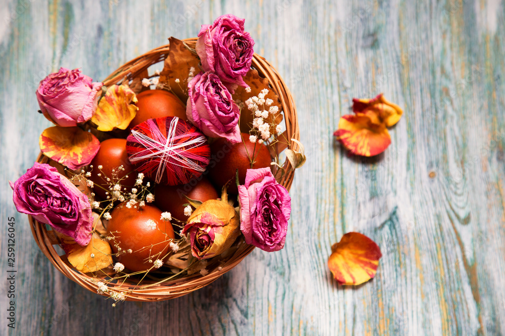 basket with easter eggs and flowers on a wooden table basket with easter eggs and flowers on a wooden table