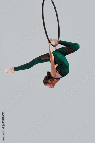 A female gymnast performing exercises on an air ring (hoop)