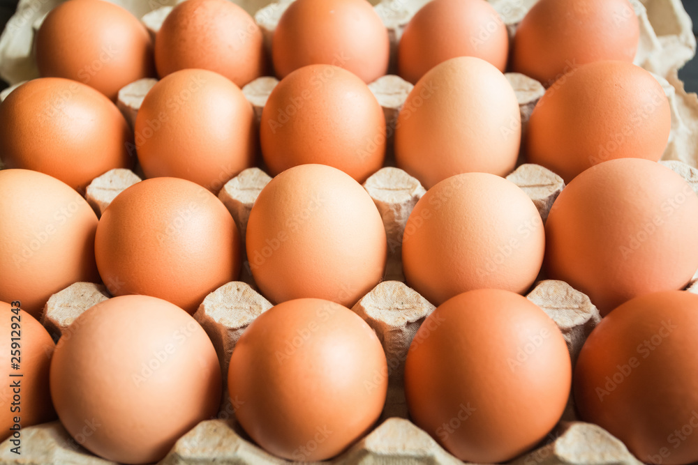 fresh chicken yellow orange eggs in a beige paper box