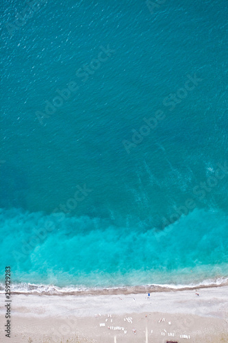 Top-down (Flat lay) view of the beach and the blue (turquoise) sea, sea holidays - bright, vibrant life;