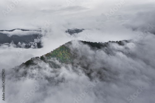 Over the forest hills. Flying above the clouds (sea of clouds) foggy view from a great height Aerial view from a height in in Abkhazia