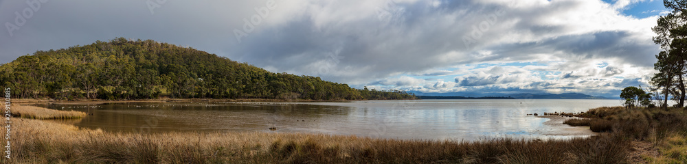 Panoramic view of a sheltered cove and hills on the coast of Bruny Island in Tasmania, Australia