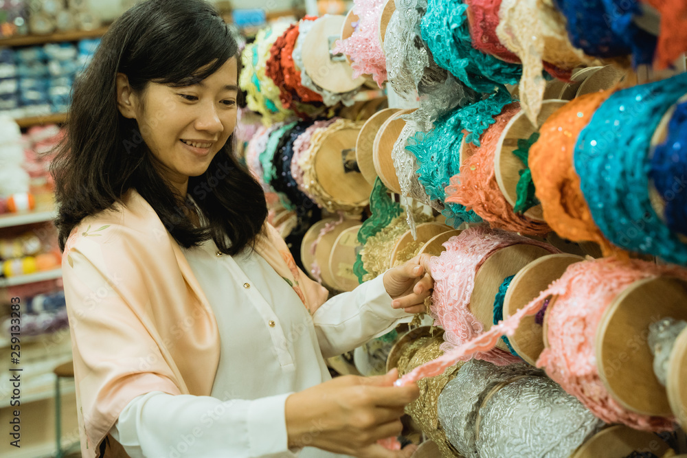 Fototapeta premium young asian woman shopping some fabric decoration and accessories