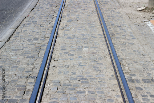 Tramway tracks straight empty perspective with cobblestone asphalt city street