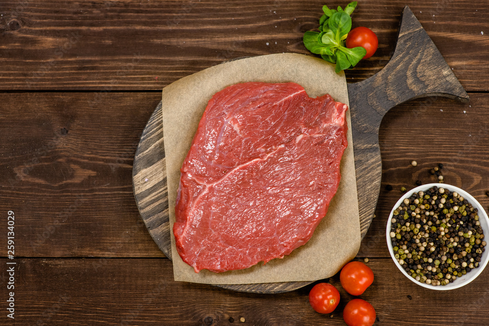 Raw meat. Raw beef steak on a cutting board. Top view. Empty space for text Raw meat. Raw beef steak on a cutting board. Top view. Empty space for text