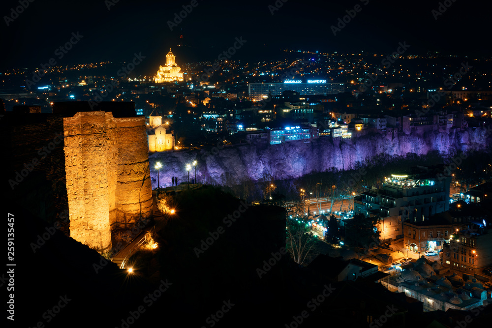 Georgia, Tbilisi - 05.02.2019. - Night view from Narikala fortress. Abanotubani, sulfur baths and holy trinity Sameba church in the background